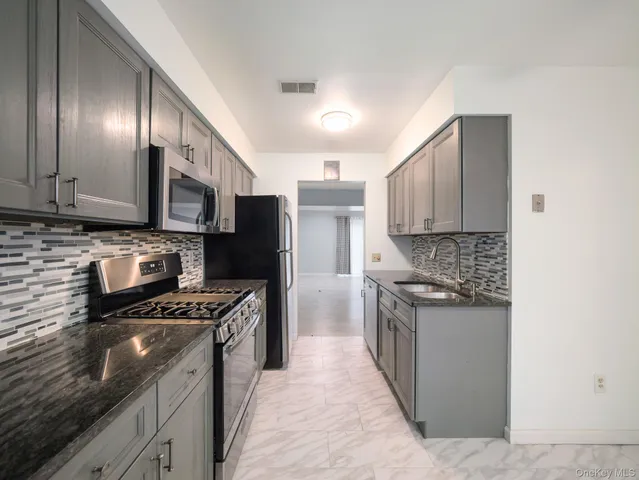 a kitchen with stainless steel appliances granite countertop a stove top oven a sink and dishwasher