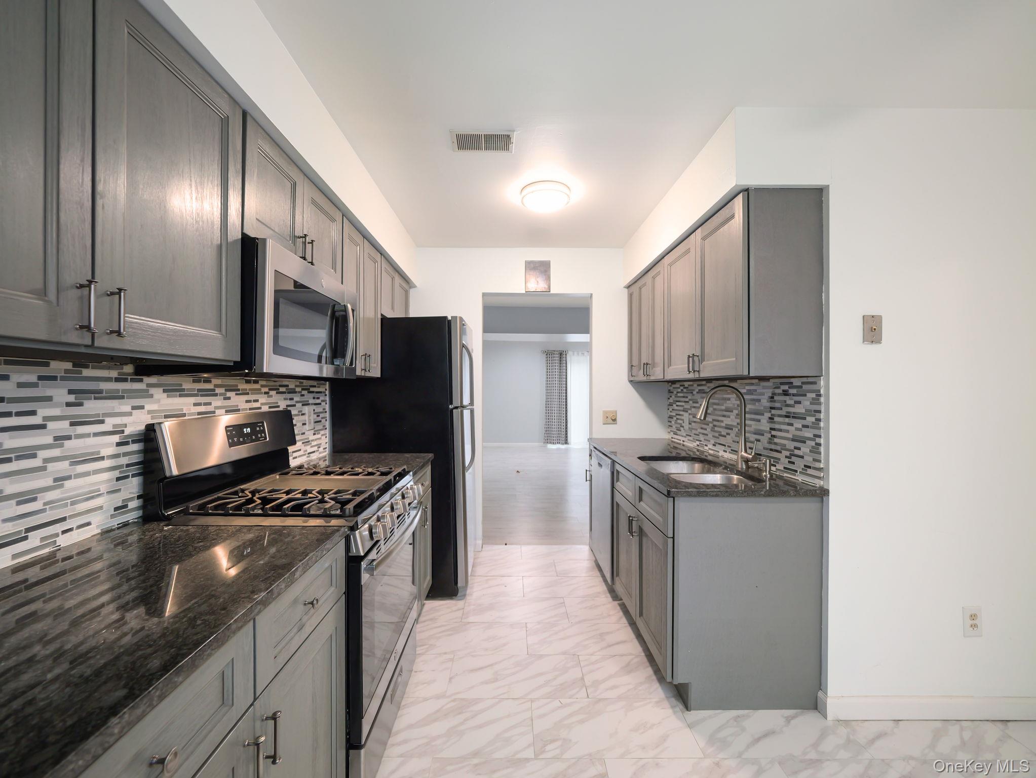 276 Temple Hill Road, Unit 707 New Windsor, NY 12553 - Photo 8 of 23 a kitchen with stainless steel appliances granite countertop a stove top oven a sink and dishwasher