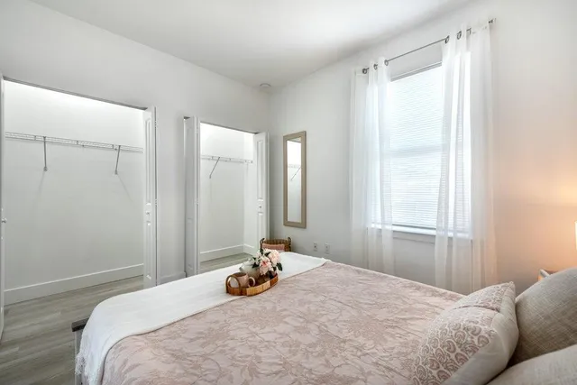 a bedroom with a bed and wooden floor