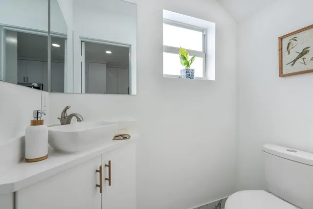 a bathroom with a sink mirror vanity and toilet