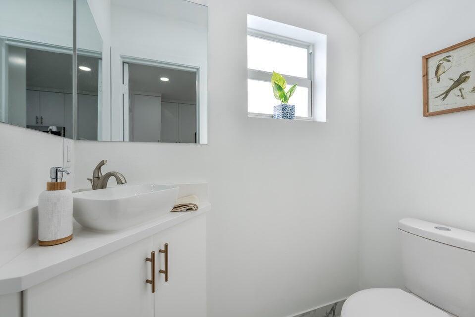 427 Northwest 13th Avenue Boynton Beach, FL 33435 - Photo 15 of 20 a bathroom with a sink mirror vanity and toilet