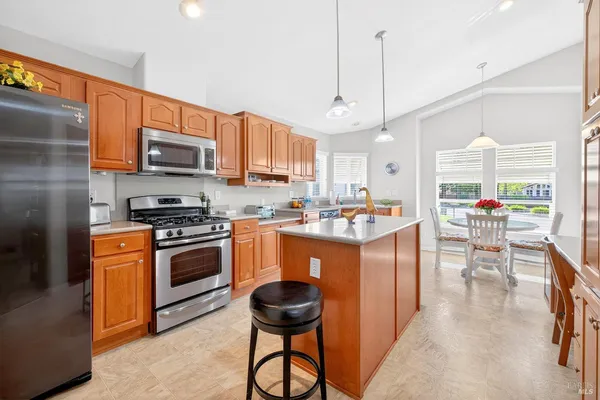 a kitchen with stainless steel appliances granite countertop a stove a sink a refrigerator and a microwave