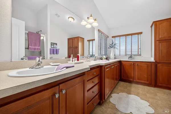 a bathroom with a sink double vanity granite and a mirror