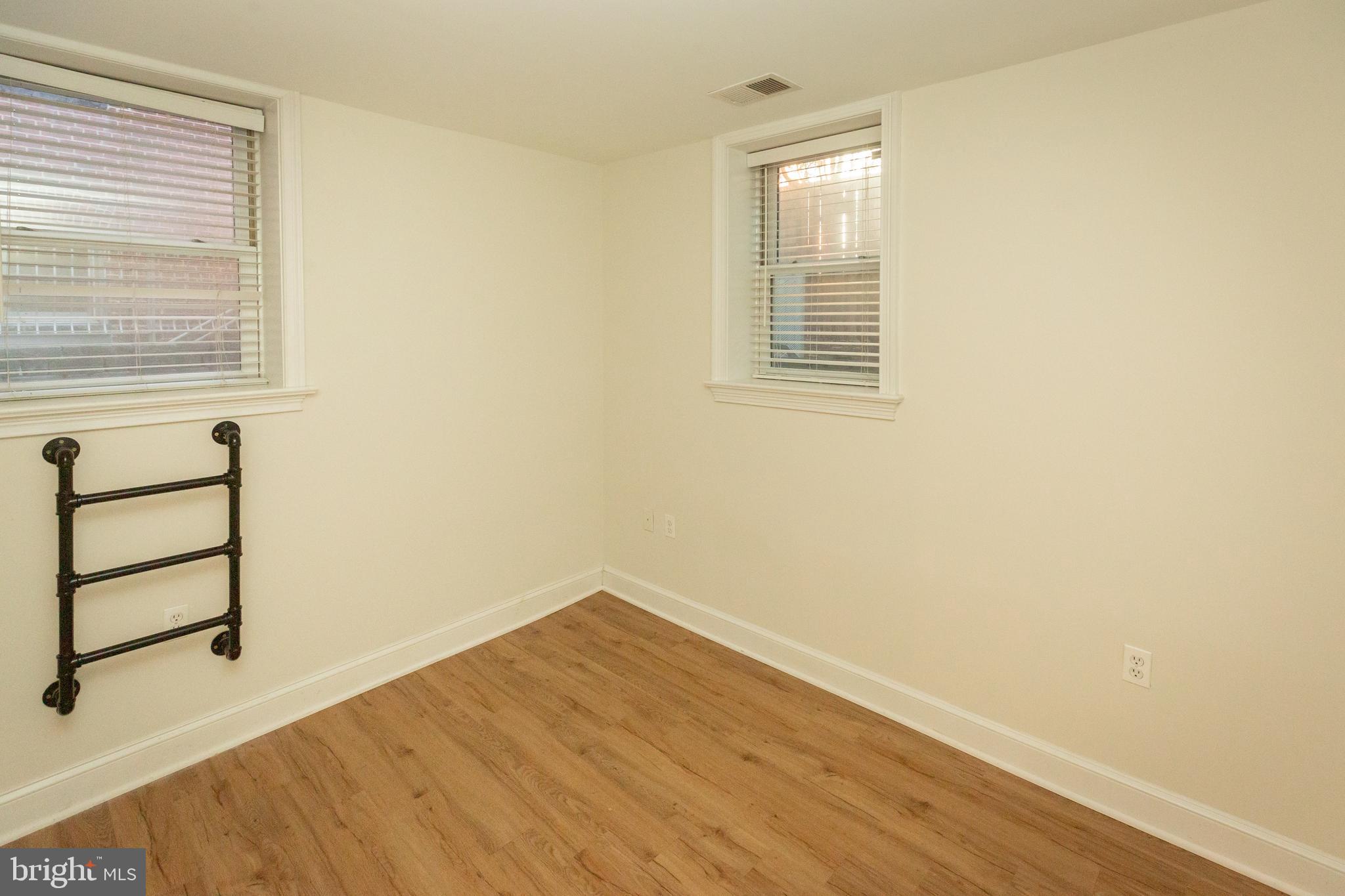 1323 Clifton Street Northwest, Unit 3 Washington, DC 20009 - Photo 20 of 32 an empty room with wooden floor and windows