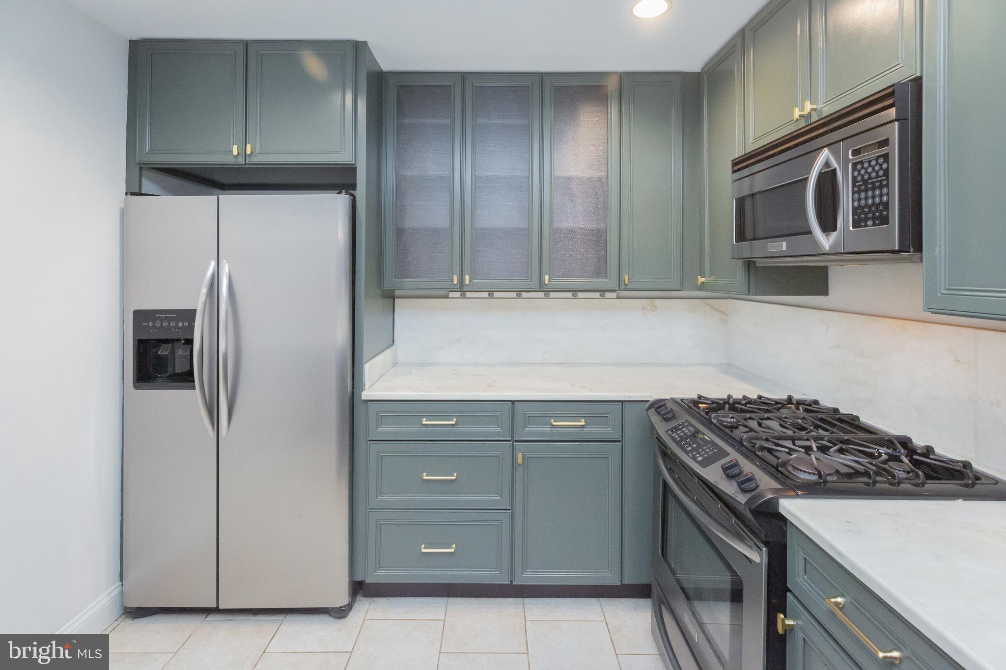 1323 Clifton Street Northwest, Unit 3 Washington, DC 20009 - Photo 5 of 32 a kitchen with cabinets and steel stainless steel appliances