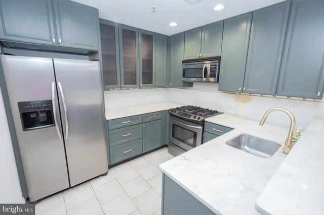 a kitchen with stainless steel appliances granite countertop a refrigerator a sink a stove a microwave and island