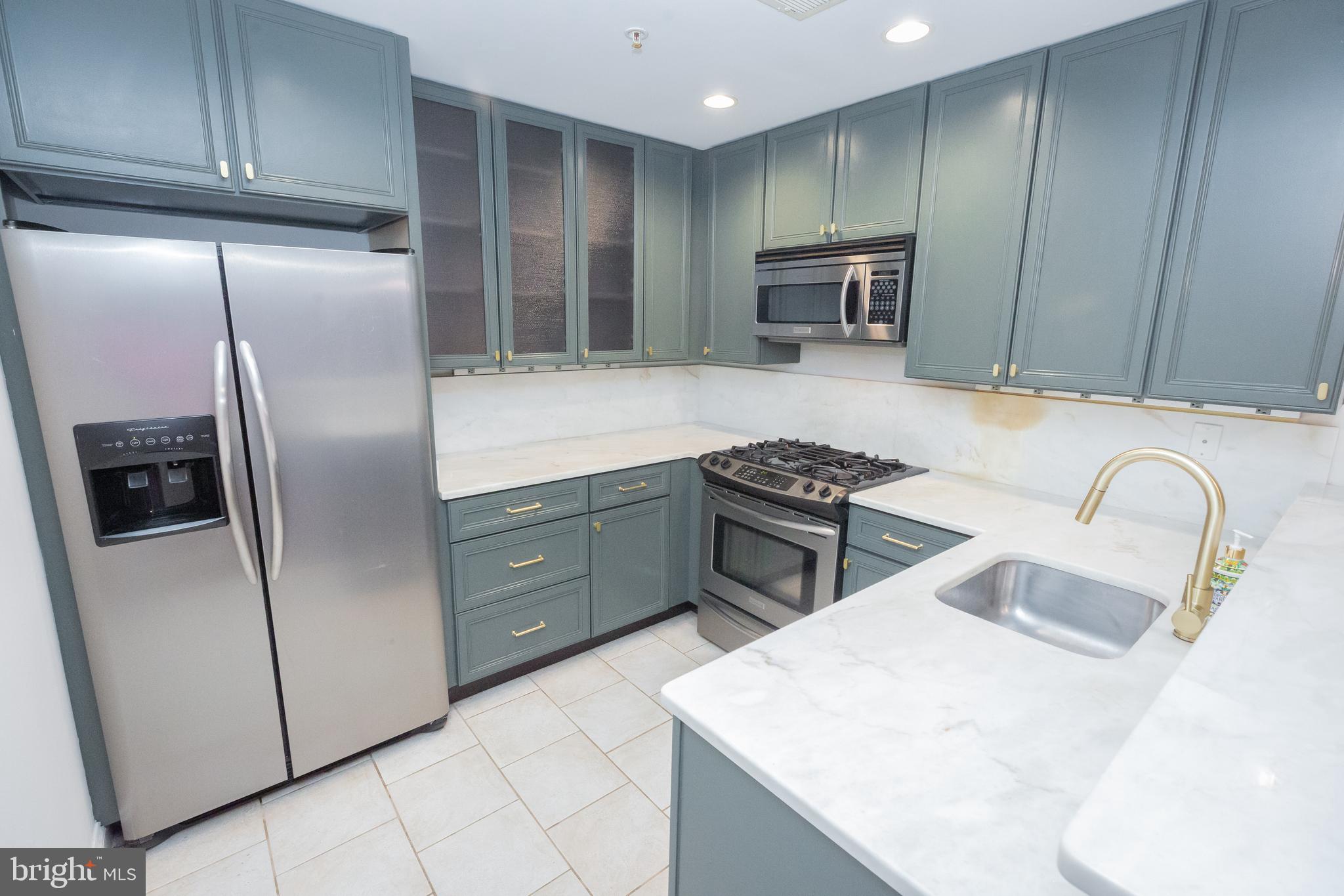 1323 Clifton Street Northwest, Unit 3 Washington, DC 20009 - Photo 6 of 32 a kitchen with stainless steel appliances granite countertop a refrigerator a sink a stove a microwave and island