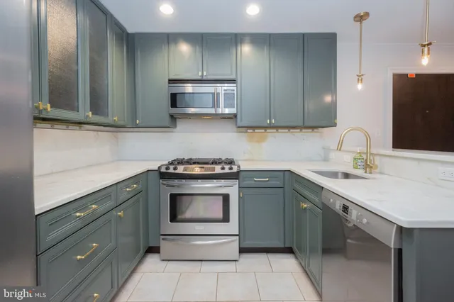 a kitchen with stainless steel appliances granite countertop a sink and a stove