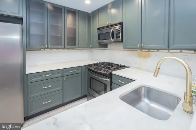 a kitchen with stainless steel appliances granite countertop a sink and a stove