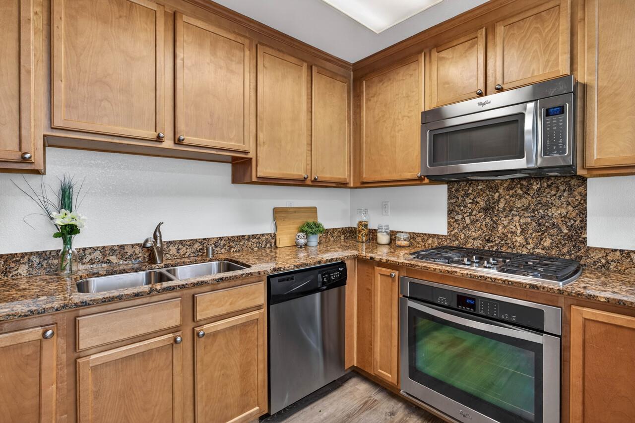 4712 Norris Canyon Road, Unit 104 San Ramon, CA 94583 - Photo 8 of 22 a kitchen with stainless steel appliances granite countertop a sink stove and microwave