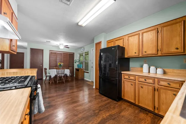 a kitchen with stainless steel appliances granite countertop a refrigerator stove top oven and sink