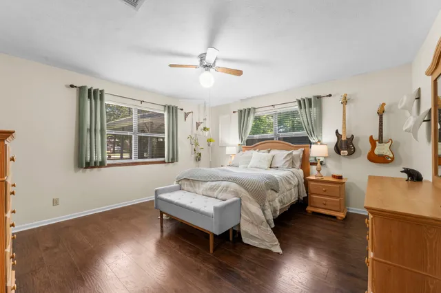 a spacious bedroom with a bed and wooden floor
