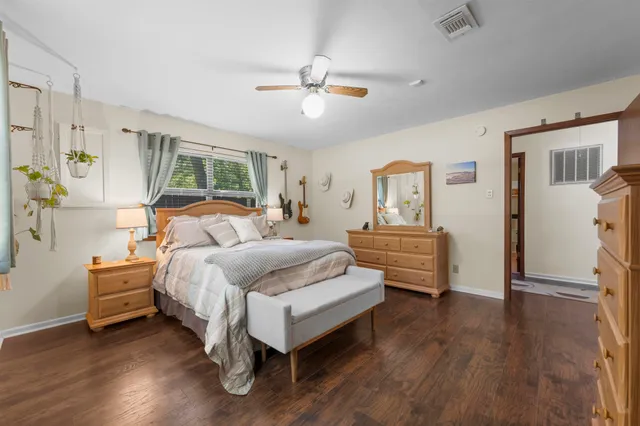 a bedroom with a bed and wooden floor