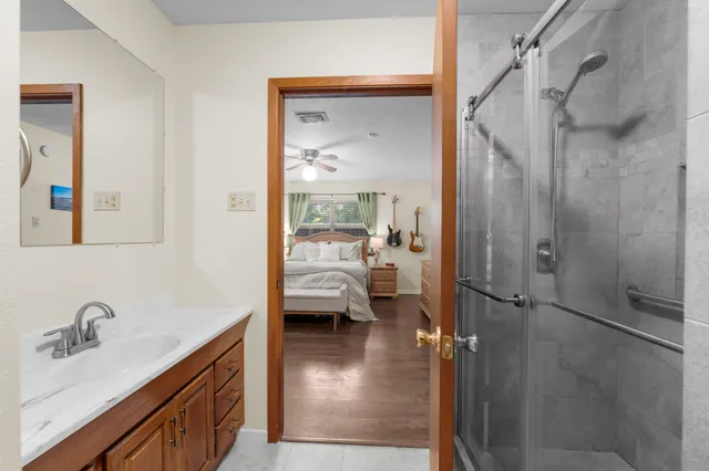 a en suite bathroom with a granite countertop sink mirror and shower