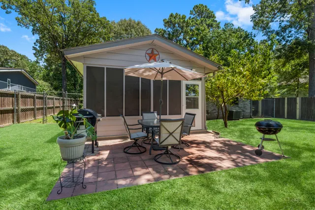 a view of a chair and table in backyard of the house