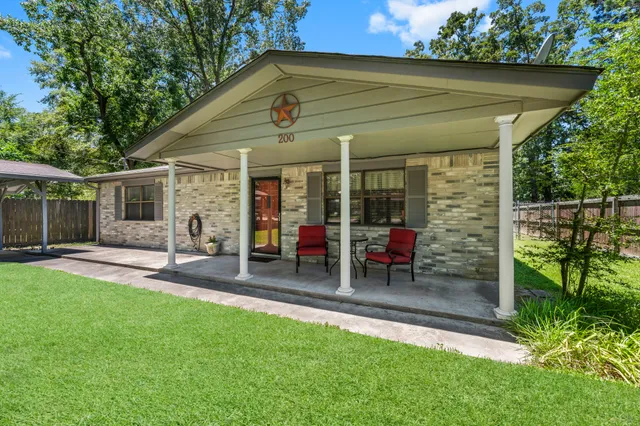 a view of a chair and table in backyard of the house