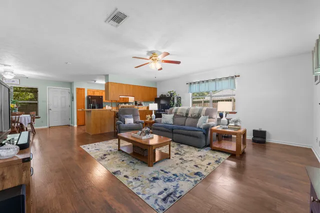 a living room with furniture a table and wooden floor