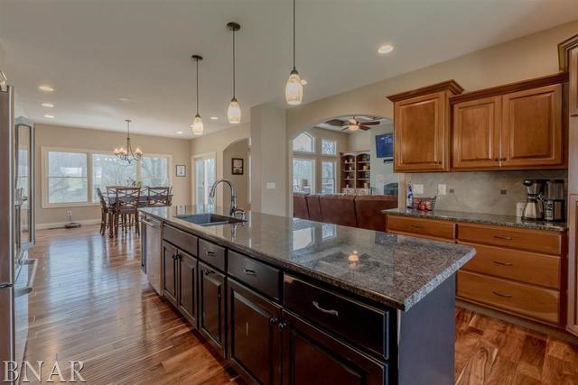 6286 Park Road Clinton, IL 61727 - Photo 5 of 45 a kitchen with granite countertop a stove a sink dishwasher and a wooden cabinets with wooden floor