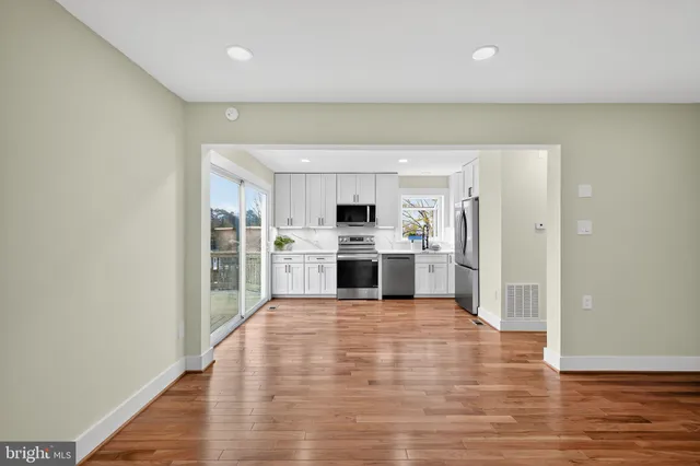 a open kitchen with a refrigerator and a stove top oven