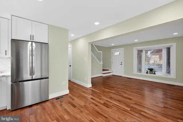 a view of empty room with wooden floor and window