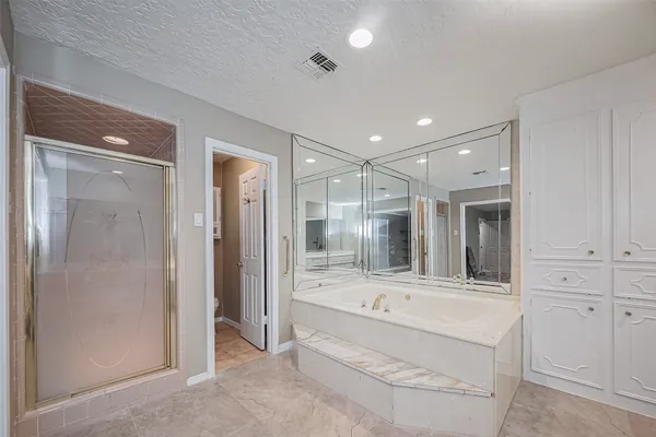 a bathroom with a tub shower and sink