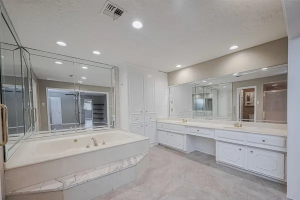 a bathroom with a tub sink and mirror