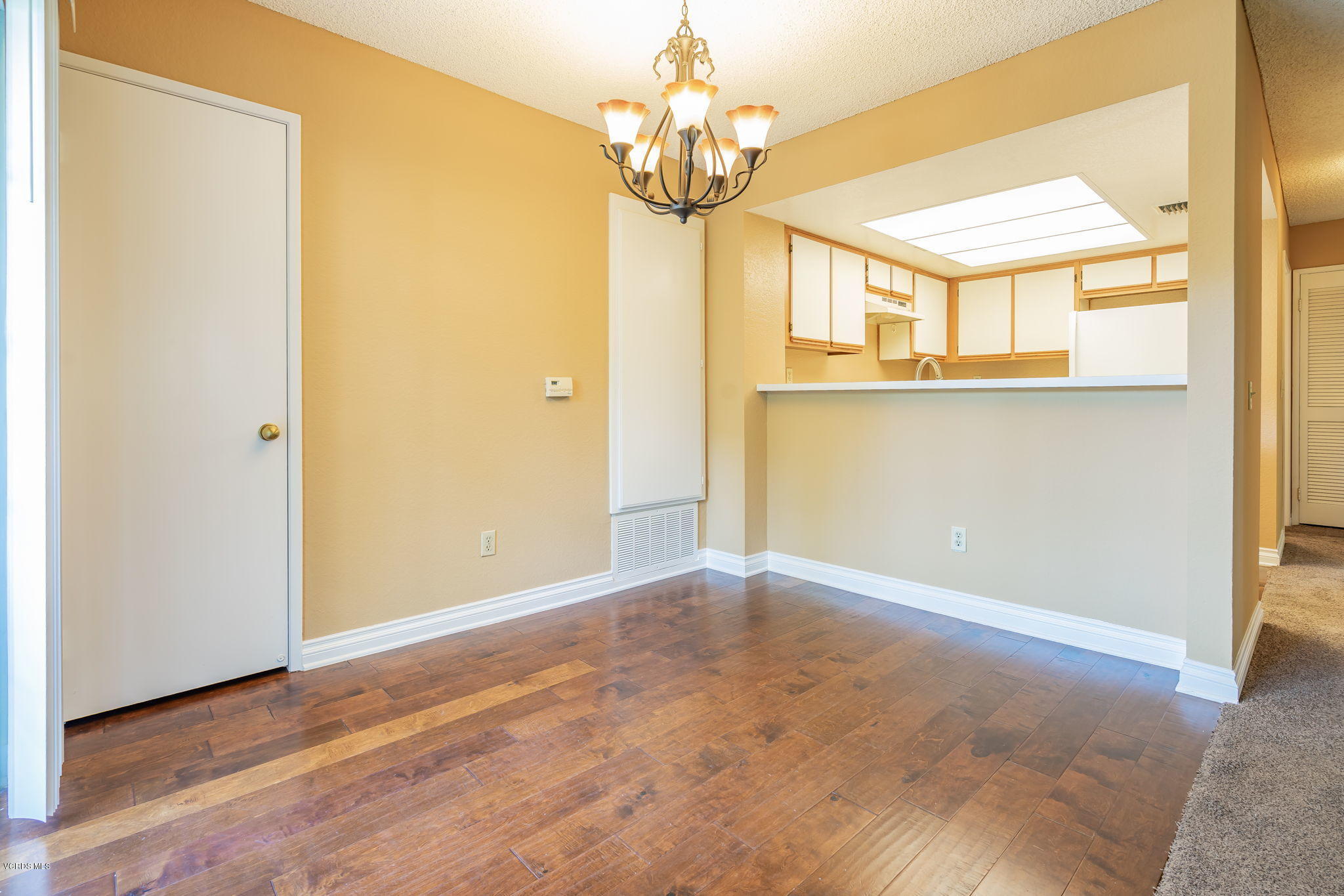 1067 Waltham Road, Unit D Simi Valley, CA 93065 - Photo 8 of 31 a view of a room with wooden floor and chandelier