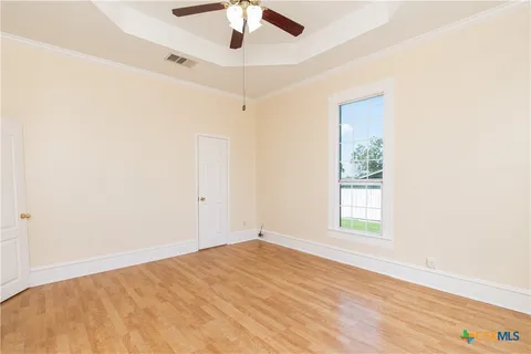an empty room with a window and ceiling fan