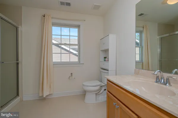 a bathroom with a granite countertop sink a toilet and a mirror