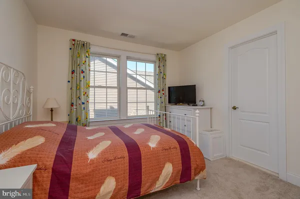 a bedroom with a bed flat screen tv and a window