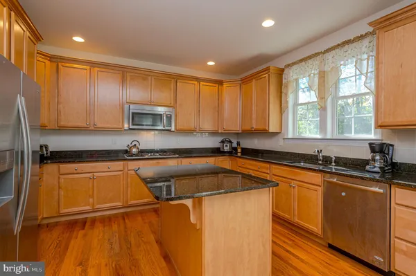 a kitchen with a sink a counter top space cabinets and a large window