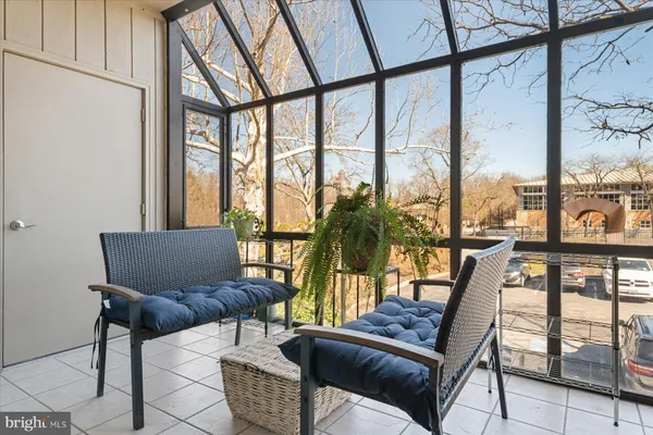 a view of a living room with furniture and floor to ceiling windows