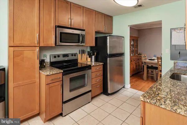 a kitchen with stainless steel appliances granite countertop a refrigerator stove and microwave