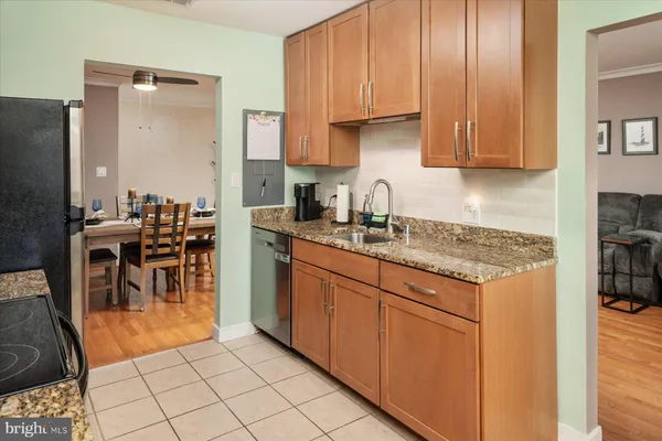 a kitchen with stainless steel appliances granite countertop a granite counter tops and a view of living room
