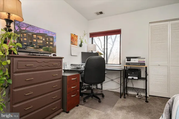 a view of a workspace with furniture and a window