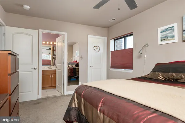a bedroom with a bed and a refrigerator