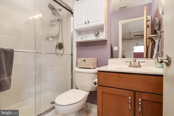 a bathroom with a granite countertop sink toilet and shower