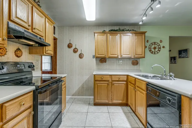 a kitchen with stainless steel appliances granite countertop a sink stove and cabinets