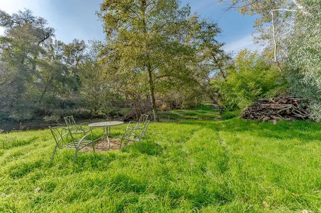 a view of a house with backyard and sitting area