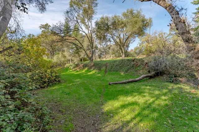 a view of a chair and table in backyard of the house