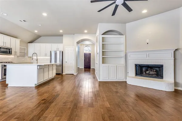 a view of a kitchen with a sink a refrigerator and a fireplace