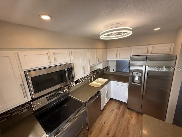 a kitchen with sink refrigerator and stove
