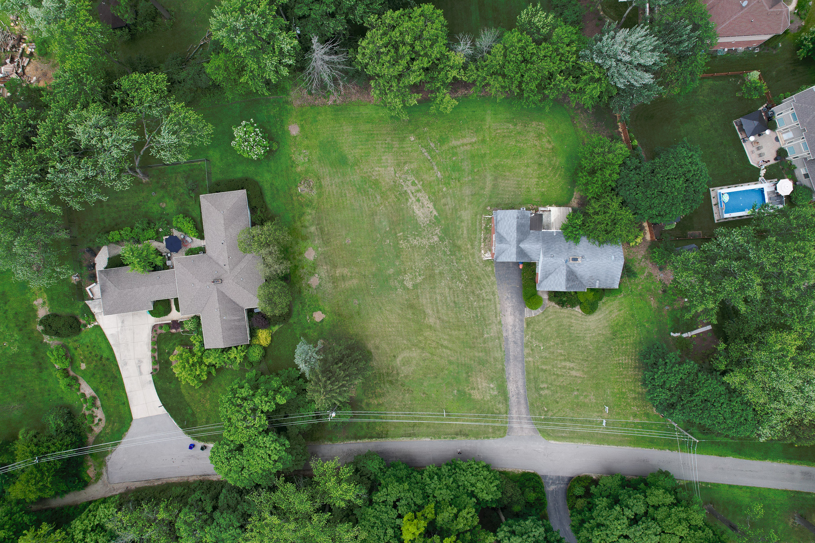 an aerial view of residential house with outdoor space and trees around