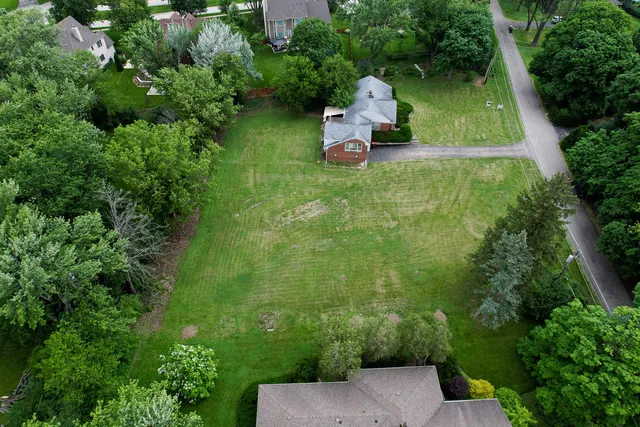 an aerial view of a house with pool garden and trees