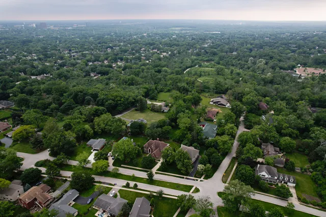 an aerial view of residential house with outdoor space and trees all around