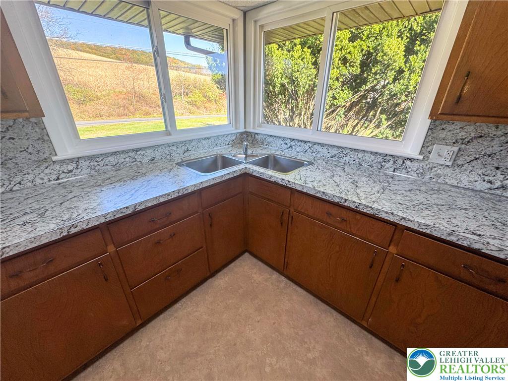 1350 Kunkletown Road, Unit 201 Saylorsburg, PA 18353 - Photo 7 of 15 a kitchen with granite countertop wooden cabinets a sink and a window