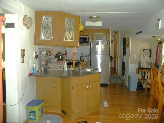 a kitchen with stainless steel appliances granite countertop a sink refrigerator and cabinets