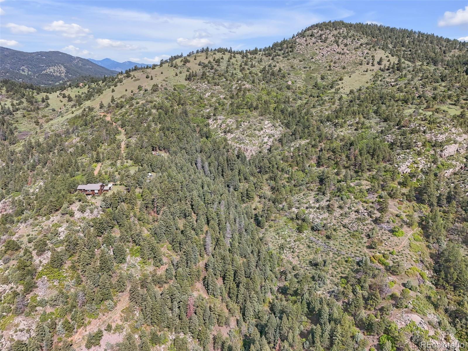 0 Raven Gulch Road Indian Hills, CO 80454 - Photo 2 of 21 a large stone wall with a mountain in the background