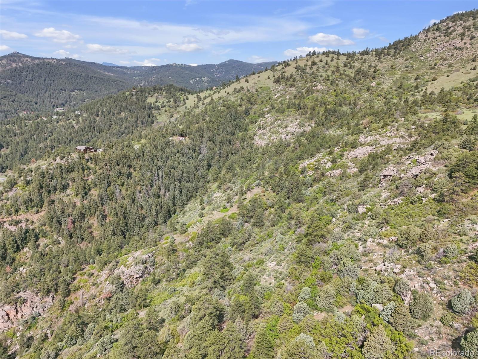 0 Raven Gulch Road Indian Hills, CO 80454 - Photo 5 of 21 a view of a large building with mountains in the background