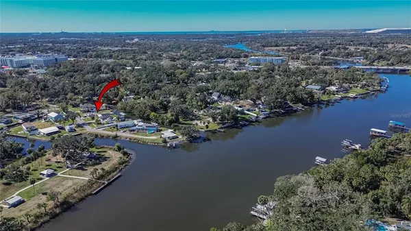 an aerial view of a house with a yard and lake view